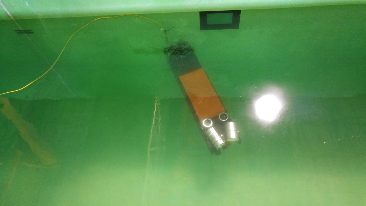 Submarine robot submerged during pool testing.