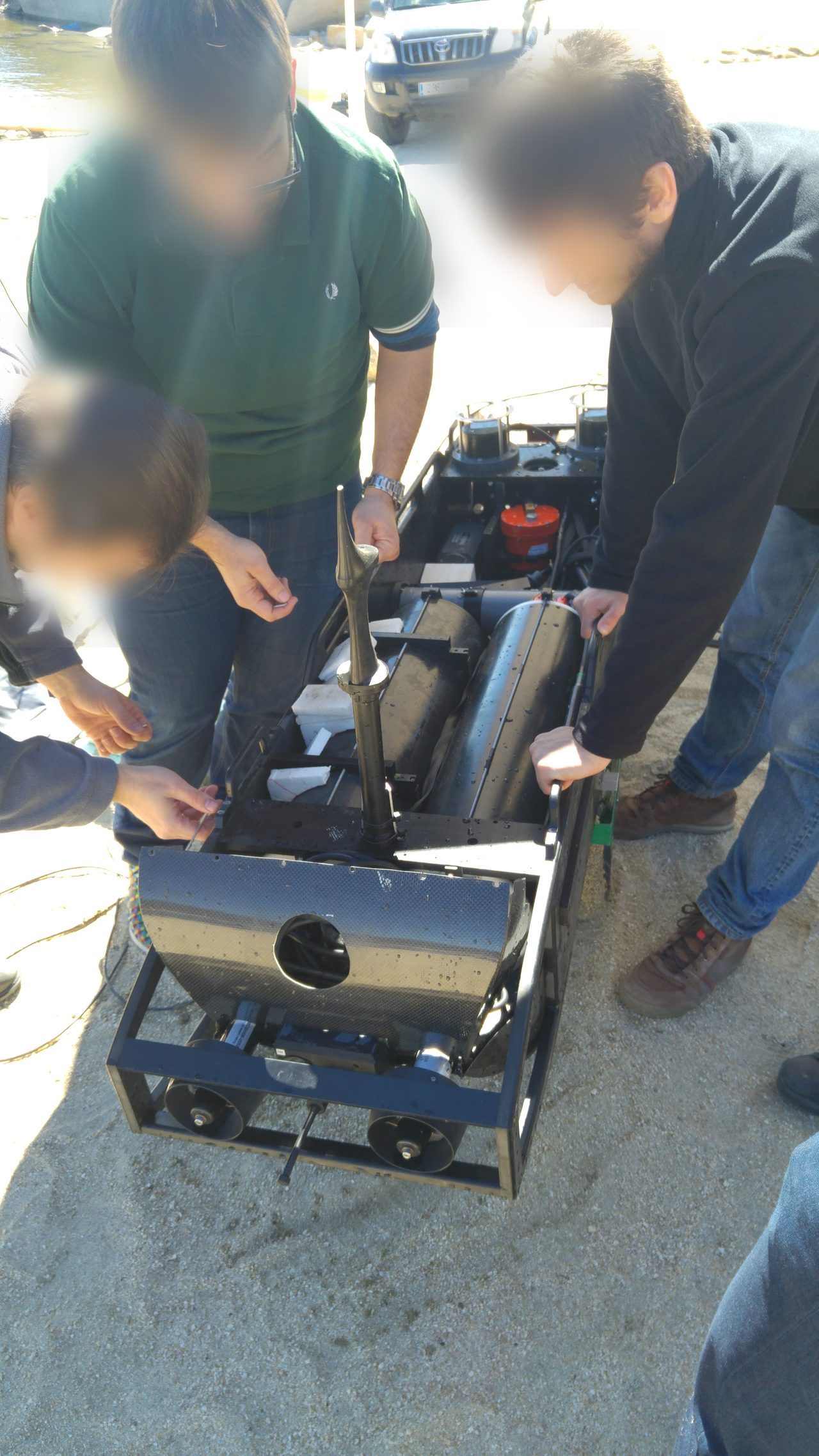 Team assembling and preparing a submarine robot for deployment.