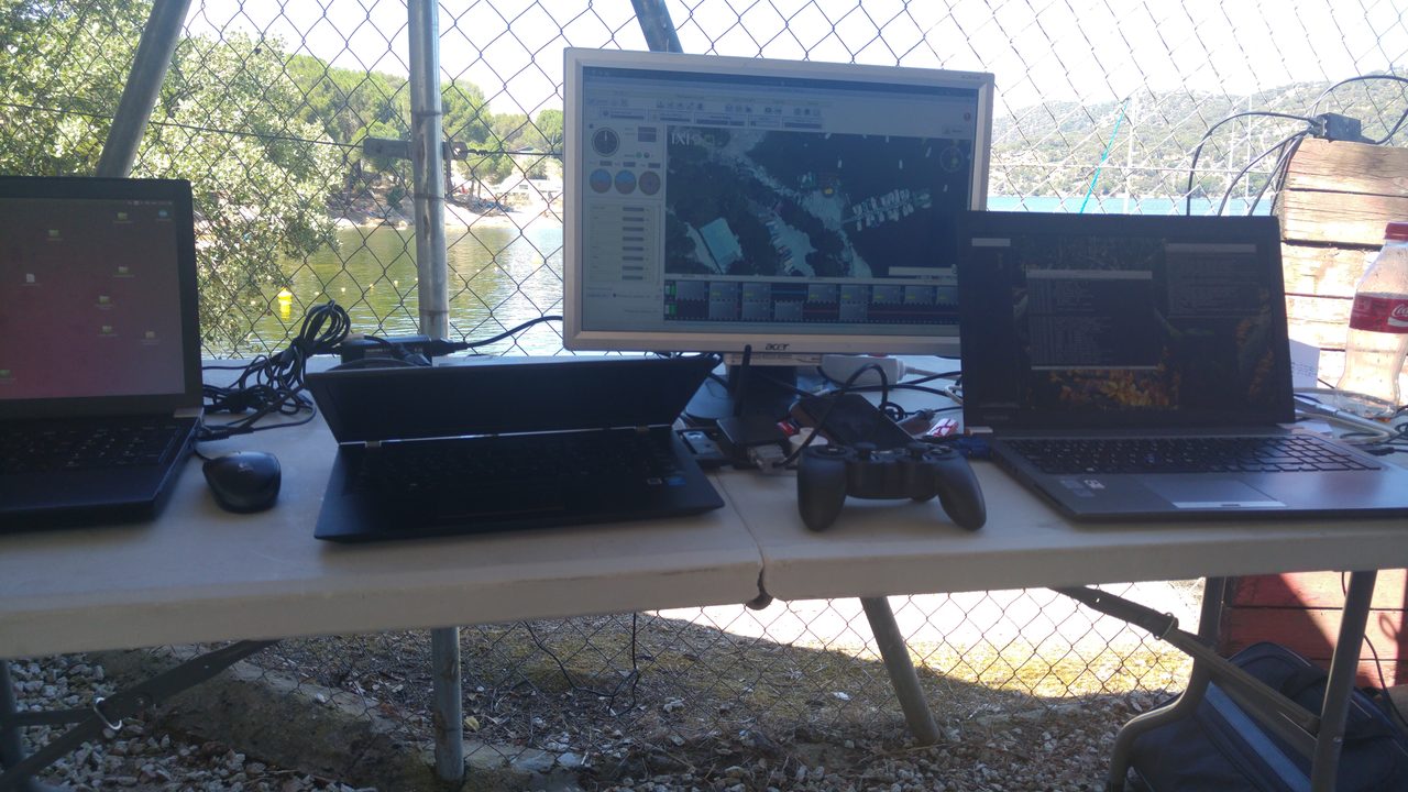 Field control station — multiple laptops and monitors overlooking the water.